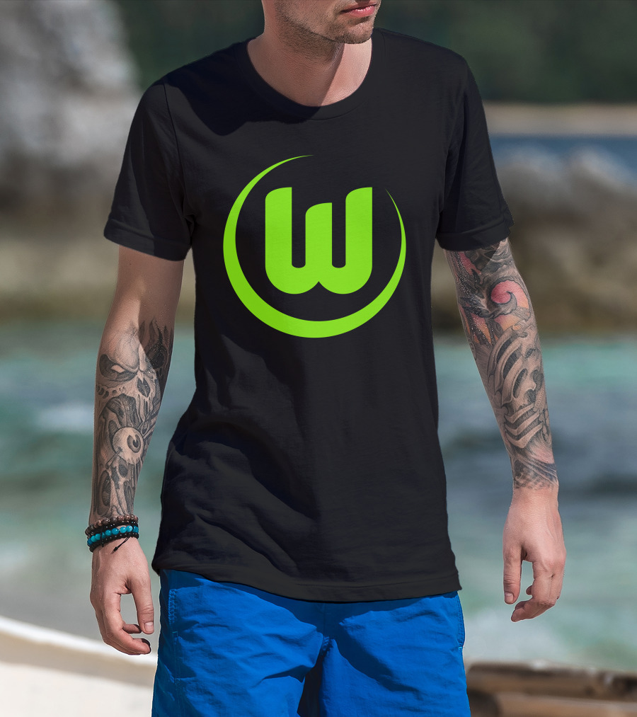Man with tattoos models Vfl Wolfsburg Die W-Green T-Shirt at beach.