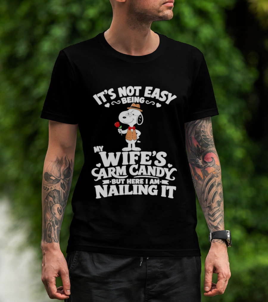 Snoopy It's Not Easy Being My Wife's Arm Candy But Here I Am Nailing It T-Shirt