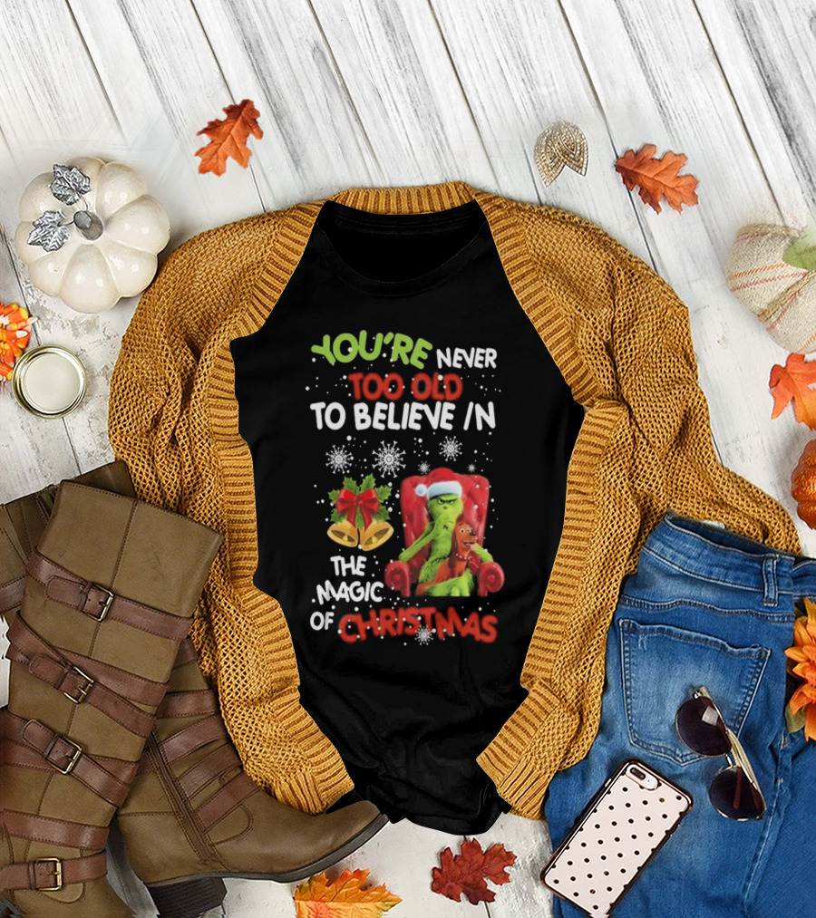 YOU'RE NEVER TOO OLD TO BELIEVE IN THE MAGIC OF CHRISTMAS GRINCH WITH MAX SITTING IN CHAIR SNOWFLAKES HOLIDAY BELLS AND BOW T-Shirt